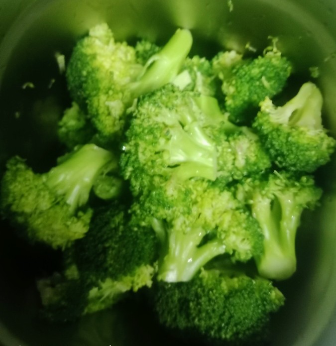 Fresh broccoli florets boiling in a metal container for soup preparation